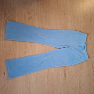 Ljusblå mjukisbyxor från Gina Tricot - Supermjuka ljusblå mjukisbyxor från Gina Tricot med raka ben och resår i midjan. Byxorna har två bakfickor och är gjorda i ett skönt fleecematerial som känns riktigt cozy. Perfekta för chill dagar hemma eller när du vill vara extra bekväm. Använd några få gånger.