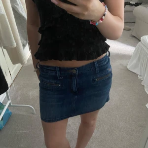 Mörkblå jeanskjol från Hollister - Säljer en snygg mörkblå jeanskjol från Hollister med två coola dragkedjedetaljer framtill. Kjolen är kort och har en figurnära passform som ger en trendig vibe. Den är i storlek w27 och perfekt nu till sommaren!🤗