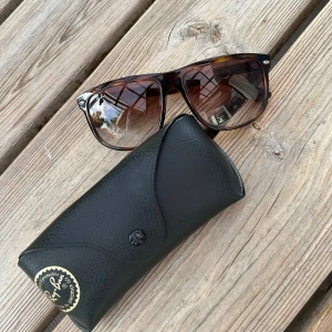 Bruna Ray-Ban boyfriend solglasögon - Snygga Ray-Ban boyfriend solglasögon med brunmelerad båge och bruna tonade glas. Klassisk fyrkantig form och diskret Ray-Ban-logga på sidan. Kommer med original svart fodral och putsduk. Pris: 800 kr! 