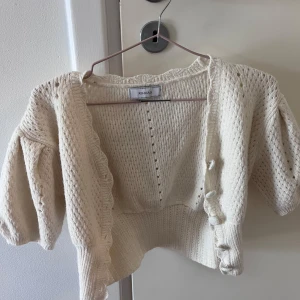 Stickad bolero - Jag säljer denna stickade boleron. Boleron är beige/creamvit och har ett jättefint stickat mönster. Säljer då den tyvärr inte kommer till användning längre. Den är i storlek s/m