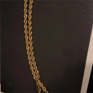 Guldfärgat tvinnat halsband - Säljer ett snyggt guldfärgat halsband med tvinnad kedja. Kedjan har en klassisk karbinhake och känns riktigt trendig och stilren. Perfekt för att lyfta vilken outfit som helst.