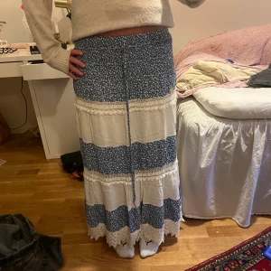 Vit och blå långkjol - Säljer denna somriga långkjol! Kjolen är i onezise men passar mej väldigt bra som ofta bär storlek 36/38, skulle även säga att den passar någon som bär en mindre/ större storlek då den är väldigt stretchiga i midjan och runt höfterna! Jag är ungefär 164 och kjolen sitter bra längdmässigt på mej. Skriv för mått!💕💕💕