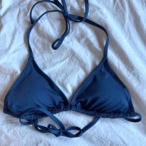 Mörkblå bikiniöverdel från 157 - Snygg mörkblå trekantsbikini från 157 med knyt i nacken och ryggen. Säljer även en likadan fast mörkgrön bikini som är en storlek större, om du vill köpa båda bikinisarna så skickar jag såklart i samma paket! 