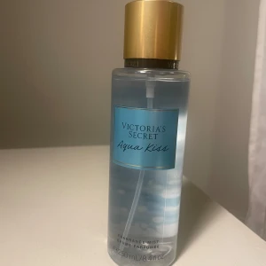 Victoria's Secret Aqua Kiss body mist - Fräsch body mist från Victoria's Secret i doften Aqua Kiss. Flaskan är genomskinlig med blå etikett och har ett lyxigt guldigt lock. Innehåller 250 ml. Perfekt för dig som gillar lätta, fräscha dofter. Jag tycker den doftar supergott, men doften passade inte mig! 💕 endast testad (ca 3 sprut), och inga defekter förutom två märken på baksidan från att ha varit i min väska (bild 2)!