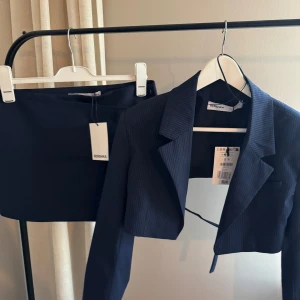 Kostym set - Berskha  - Kostym sett från Berskha, helt nytt💙 Blazern är croppad och har spännes detaljer.  - Storlek: Small  - Ord pris: 399kr Kjolen har under shorts och är en ”byxkjol”, denna har också spännes detaljer. - Storlek: 38 - Ord pris: 379kr  Köpte setet för 778kr ⭐️