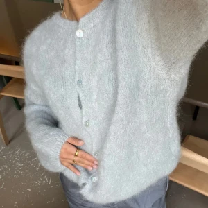 Ljusgrå mohair kofta - Supermjuk och fluffig ljusgrå kofta med rund hals och stora vita knappar framtill. 80% mohair från designbysi i storlek xs/s, aldrig använd!! Öppen för prisförslag!