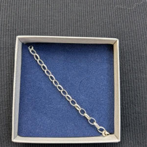 Silverarmband från Thomas Sabo - Stilrent armband i silver från Thomas Sabo med ovala länkar och en rund berlock med märkets logga. Perfekt att bära som det är eller att kombinera med andra smycken för en personlig look. Armbandet är aldrig använt bara testat