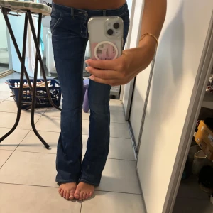 Blå bootcut jeans med låg midja - Säljer ett par snygga blå jeans från dondup med bootcut-modell och låg midja. 