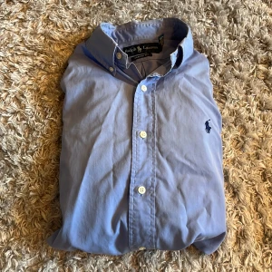 Ralph Lauren skjorta - Säljer denna snygga Ralph Lauren skjortan i storlek S, classic fit. Den är i ganska bra skick men har tyvärr lite missfärgning i armhålorna, men inget som syns vid användning. Bara att skriva över frågor och funderingar.