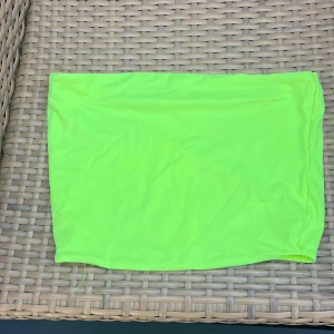 Neongul top - Enkel och snygg neongul top i stretchigt material. Toppen har en rak och tight passform, perfekt för dig som vill sticka ut med en poppig färg. Passar till sneakers eller boots för en cool look.
