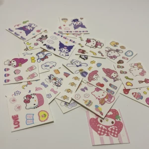 Söta Sanrio pappers-märken - Ett gäng små pappers-märken med Hello Kitty, My Melody och Kuromi i pastellfärger. Motiven inkluderar sminkprylar som läppstift, rouge och speglar blandat med cupcakes, hjärtan och söta figurer. OBS: Inte klistermärken! De är bara gjorda av papper!
