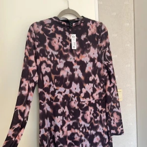 Lång klänning Lindex XL - Helt ny långklänning från Lindex i storlek XL med ett  blommigt mönster i mörka lila och rosa toner. . Mjuk och stretchig känsla o väldigt skön material, passar perfekt nu till sommaren! 