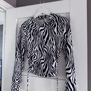 Zebramönstrad långärmad topp - Zebra topp med öppen rygg och snörning. Aldrig använd, storlek s