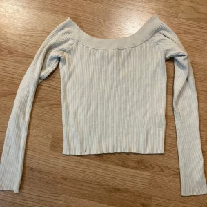 Offshoulder beige ribbad topp från Bik  - Snygg offshoulder topp från Bik Bok i ljusbeige färg. Modellen är ribbad och har långa ärmar, vilket ger en stilren look. Storlek XL men passar M och S.