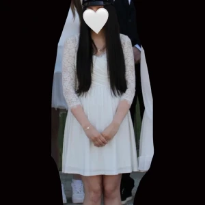 Vit spetsklänning med trekvartsärm - Superfin vit kortklänning från Chiara Forthi med spetsdetaljer och trekvartsärmar. Klänningen har omlott framtill, markerad midja och vackert fall. Spetsen är blommig och ryggen har en snygg öppning. Perfekt för student, skolavslutning eller sommarens speciella tillfällen!