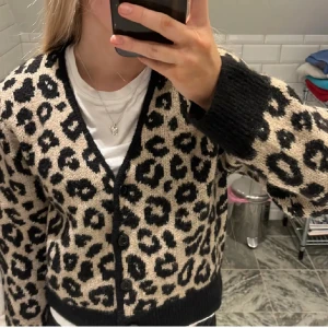 Leopardmönstrad kofta med svarta detaljer - Snygg kofta med leopardmönster i beige och svart. 