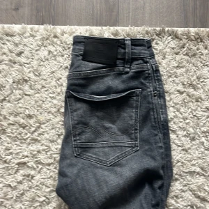 Grå jeans Skinny Straight Jack & Jones - Snygga grå jeans från Jack & Jones i modellen Skinny Straight. Jeansen har klassisk femficksdesign, normal midja och raka ben. Materialet är mjukt denim i bomull med en lätt tvättad look. Perfekta för dig som gillar en clean och stilren vibe. Original 800.