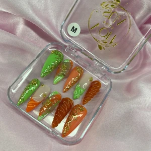 CitrusLuxe (M);Long Stiletto - Snygga gelé press-on naglar i mix av grönt, orange och nude med guldiga detaljer och 3D-effekt. Långa, spetsiga former och cool trend-design. Kommer i genomskinlig ask. Perfekt för dig som vill sticka ut med din nagelstil. I storlek M: 16 mm, 12 mm, 12,5 mm, 11,5 mm, 10 mm 