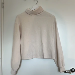 Beige polotröja i manchester Gina Tricot - Supermjuk beige polotröja från Gina Tricot i manchester. Tröjan har lång ärm, relaxed fit och ribbad struktur. Liten defekt: fläck på framsidan vid vänster nederkant.