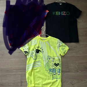 Svart Kenzo t-shirt med logga - Svart t-shirt från Kenzo med färgglad Kenzo Paris-logga tryckt på bröstet. Klassisk passform och rund halsringning, perfekt för en stilren och trendig look. Man kan även välja att köpa tröjorna separat