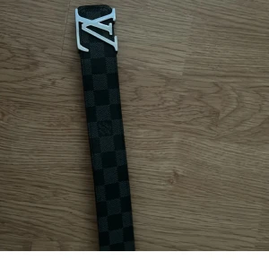 Rutigt svart bälte med silvrigt märke - Den är I jättebra skick köptes för ca 1000kr, pris kan diskuteras 