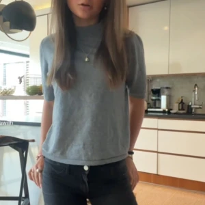 Ljusgrå stickad polotröja - Säljer en ljusgrå stickad polotröja med korta ärmar. Tröjan är i storlek xs och kommer ifrån Stockholm lm