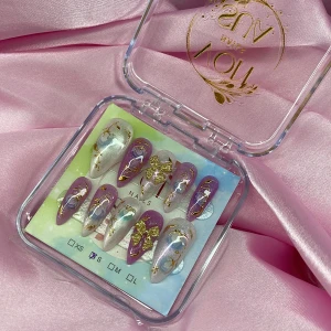 Tecna (S);Medium Stiletto;Curved - Snygga gelé press-on naglar i storlek S: 15 mm, 11,5 mm, 12 mm, 11 mm, 9 mm, med lila och vita nyanser, dekorerade med handmålade blommor, skimrande yta och detaljer i guld. Några naglar har glittriga guldrosetter. 