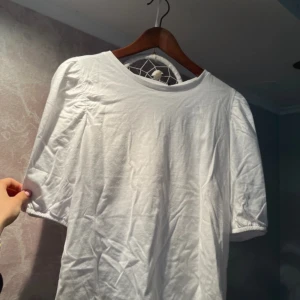Vit t-shirt med puffärm  - Vit t-shirt med puffärm från lager 157, aldrig använt. Storlek M men passar S också💗komma gärna in mina andra inlägg så kan man köpa en bundle!