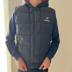Moncler väst - Moncler väst säljes, Västen är röd inuti och har moncler text inuti som följs jämte dragkedjan, Moncler västen Kan inte garantera äktehet, kan bytas också, skriv vid minsta funderingar osv🤗