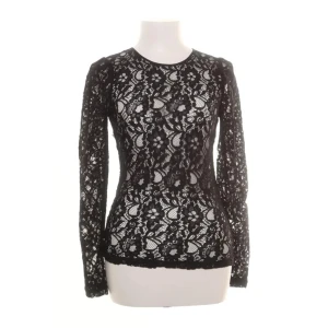 Svart spetsblus med liten puff ärm - Svart blus från Oasis i genombruten spets med blommigt mönster och nätta puffärmar. Långärmad och figurnära modell med rund halsringning och knapp i nacken. Perfekt för dig som vill ha en feminin och trendig look. Fin att ha med ett linne under, eller under en klänning.