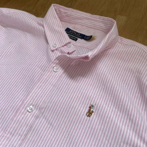 Rosa ralph lauren skjorta - En riktigt snygg rosa och vitrandig ralph lauren skjorta i storlek L Classic fit. Hör av er vid frågor