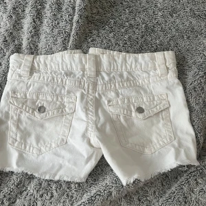 Vita jeansshorts med rå kant - Säljer mina vita Lågmidjade jeansshorts från gina young 