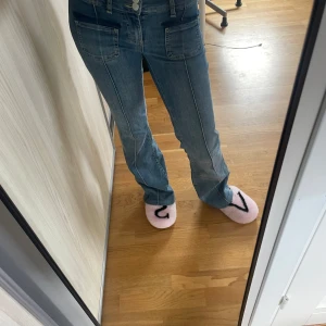 Blå bootcut jeans från Nelly - Säljer ett par blå bootcut jeans från Nelly med snygga framfickor och dubbla knappar i midjan. Jeansen har markerade sömmar längs benen och en klassisk tvättad denimlook. Perfekta för dig som gillar en retro vibe och vill ha något som sticker ut. Andvända fåtal gånger.  Nypris ca 700kr