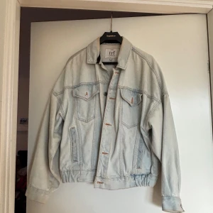 Oversized ljusblå jeansjacka Zara TRF - Säljer en oversized ljusblå jeansjacka från Zara TRF. Jackan har klassisk krage, knappar framtill, två bröstfickor med lock och två sidofickor. Snyggt rynkad nederkant bak och långa ärmar med knapp vid ärmslut. Perfekt för en chill och trendig look.