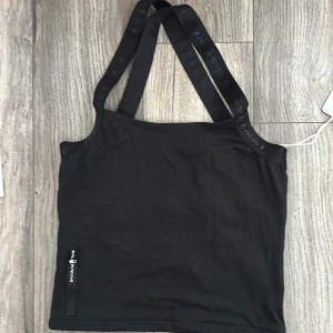 Svart linnetopp från Sail Racing XS - Sportig svart linnetopp från Sail Racing med breda axelband some korsade i ryggen. Logga och meshdetalj i ryggen. Snygg och enkel design, perfekt för dig som gillar en clean look och vill ha något bekvämt till träning eller sommarens äventyr. Aldrig använd. Nypris 600kr. XS/S. Använd gärna Early Bird som fraktalternativ. 