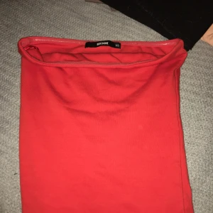 Röd tubtopp från BikBok XS - Säljer en enkel och snygg röd tubtopp från BikBok i storlek XS. Toppen är axelbandslös och har en klassisk bandeau-form, perfekt att matcha med jeans eller kjol. Mjuk och stretchig bomullskänsla som sitter skönt på kroppen.