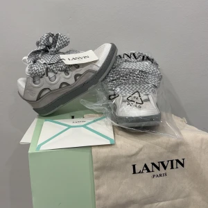 Lanvin Curb - Lanvin sneakers i vitt och grått skinn med chunky grå sula och breda.  Snygg vågig detalj längs sidorna och perforerad tå. Perfekta för dig som vill sticka ut med en unik och trendig look. Helt nya, passade inte riktigt min stil. Priset kan diskuteras!