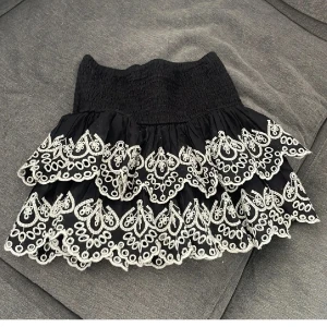 Svart volangkjol med broderad spets💕 - Supersöt svart kortkjol med vita volang detaljer💕 superfin men kommer tyvärr inte till användning💝 väldigt bra skick, knappt använd och säljs inte längre🥰 strl 170 men passar xs/s🤍
