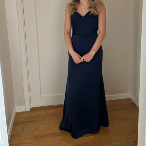 Mörkblå balklänning - Säljer denna jättefina mörkblåa balklänningen med öppen rygg. Den går hela vägen ner till golvet för mig som är 167cm lång. Jag hade den på 9:ans bal och är därför använd en gång. Jag köpte den för 1400kr💞🤗