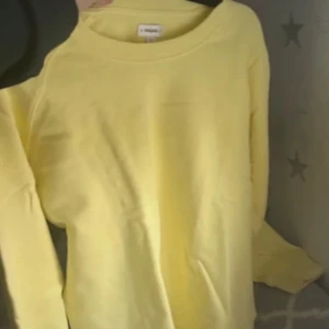 Gul långärmad sweatshirt i bomull - En basic gul långärmad sweatshirt. Tröjan har rund halsringning och är gjord i mjuk bomull, perfekt för en chill och avslappnad stil. Enkel design utan tryck eller mönster, passar till jeans eller mjukisbyxor.