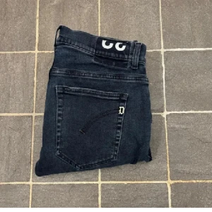 Dondup jeans - Säljer ett par dondup jeans i riktigt fet mörkblå/svart tvätt, med klassisk femficksdesign och knappgylf. I modellen ritchie (sitter exakt som de mest populära George) Jeansen har en smal passform och är i slim/skinnyfit och är tillverkade i stretchigt bomullsmaterial för extra komfort. Perfekta för dig som gillar en exklusiv och snygg look och stilrena detaljer. Nypris 4000:- mitt pris endast 649:-