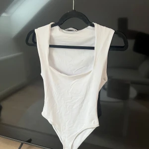Vit Zara body - Säljer min super fina vita Zara body då jag har tröttnat på den. Lite små tecken på andvändning så som ett litet hål i sömnen som man ser på bilden och en liten sminkfläck på insidan av bröstet som då inte syns när man har på sig den. Annars är den väl som ny skulle jag säga. 