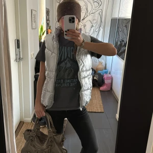 Silverfärgad dunväst - Snygg och glansig silverfärgad dunväst med dragkedja. Västen har en hög krage och är quiltad för extra stil och komfort❣️