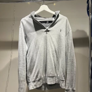 Grå half zip från Ralph Lauren - Säljer en stilren grå half zip från Ralph Lauren med en liten logotyp på bröstet. Tröjan har en bekväm passform och långa ärmar. Perfekt för en avslappnad look. Hör av er för frågor!