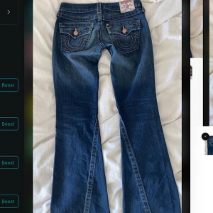 Blå low waist bootcut jeans från True Religion - Snygga blå jeans från True religion i modellen joey. Byxorna har en bootcut-stil och är dekorerade med knappar på bakfickorna. Väldigt lowwaist men sitter väldigt bra💕 inga defekter 😊 Midja 33cm, innerbenslängden ca 78cm
