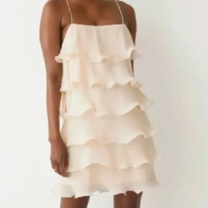 Champagnefärgad klänning med volanger - Säljer denna fina klänningen från & other stories i storlek xs/s🫶🏼 då den knappast är använd❣️