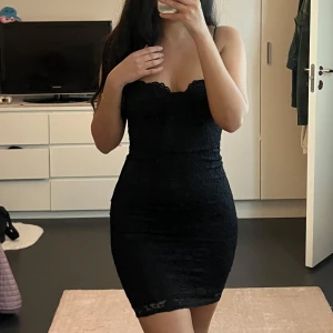 Svart spetsklänning - Snygg svart klänning i spets med tight passform.  Köpt från Nelly, storlek XS