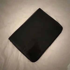 Svart datorväska från Åhlens - Snygg och stilren svart datorväska med ormskin mönster från Åhlens. Enkel design som passar till alla tillfällen.