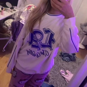 Vit sweatshirt från H&M Divided - Säljer en vit sweatshirt från H&M Divided med blå text 'LA' på framsidan. Tröjan har långa ärmar och en avslappnad passform. Perfekt för en casual look! 💙 den är oversized och jätteeeee skön😊