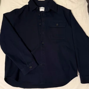 Mörkblå overshirt  - Snygg mörkblå overshirt från selected homme med långa ärmar och knappar framtill. Perfekt för lager-på-lager-stil under kyligare funkar även bra med endast T-shirt.  . Overshirten är nästan helt ny. Skick 9/10 priset är diskuterbart. Hör av dig vid funderingar eller fler bilder!